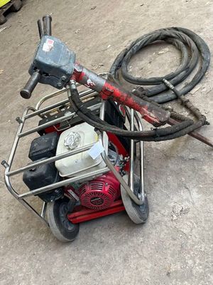 a small machine that is sitting on the ground next to a hose