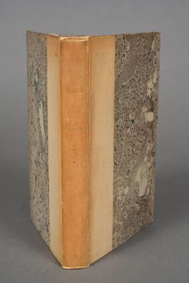 an old book sitting on top of a table next to a gray wall