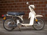 a motor scooter that is parked in front of a brick wall