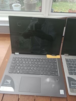 two laptops sitting on a table next to each other
