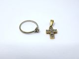 an image of a ring and a cross pendant on a white surface