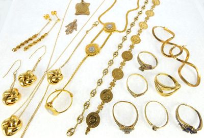 a lot of gold jewelry on a white table