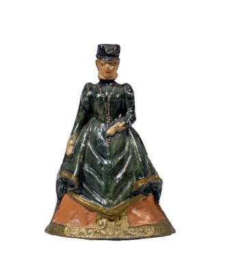 figurine of a woman wearing a green dress and a black hat