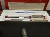 a box with pens and a pen in it on a table