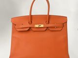un sac à main en cuir marron avec des ferrures dorées sur la poignée
