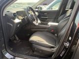 the interior of a car with the door open and the driver ' s seat down