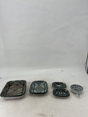 three green and white dishes sitting on top of a white surface