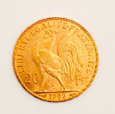a gold coin with a rooster on it on a white surface