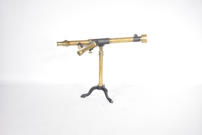 an antique brass telescope on a tripod stand on a white background