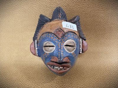 a mask on a gold background with a tag on it