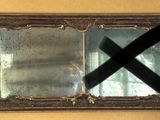 a reflection of a person in a mirror with a black cross on it