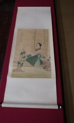 un tableau représentant une femme en robe verte posée sur une table rouge