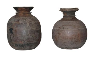 two vases sitting next to each other on a white surface