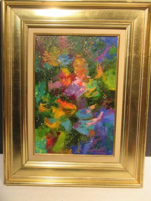 une peinture à l'huile représentant des fleurs, dans un cadre doré, posée sur une table
