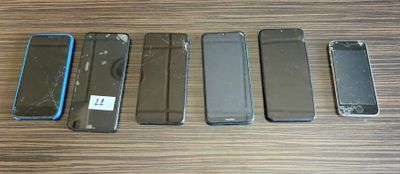 six téléphones portables sont alignés sur une table