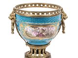 a blue and gold vase with flowers in it on a stand