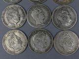 six silver coins of different sizes and shapes on a blue surface