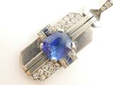 une image représentant un pendentif composé d'un saphir bleu et de diamants, sur fond blanc