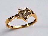 un gros plan d'une bague en or ornée d'une étoile en diamant