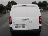 a white van parked in a parking lot with trees in the background