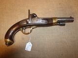 un vieux pistolet, muni d'une étiquette, posé sur une table