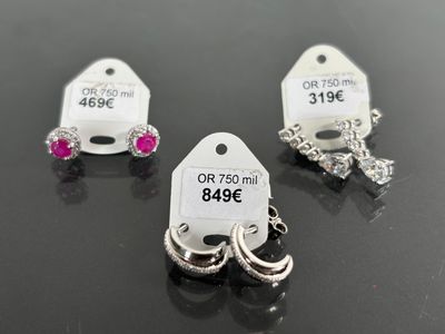 three tags are shown on a table with a pair of rings