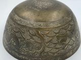 an old brass bell with a bird design on it