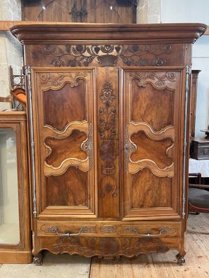 an antique wooden armoire with a glass door and a mirror
