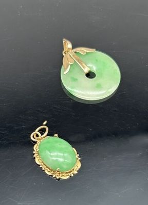 trois bijoux en jade vert et en or sur un fond noir