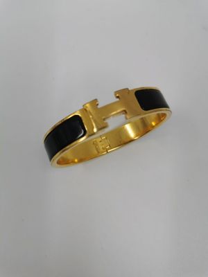 un bracelet noir et doré orné d'une croix