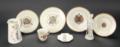 cinq assiettes, un pichet et un vase posés sur une table
