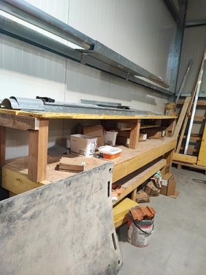 un établi dans un garage, sur lequel se trouvent de nombreux outils