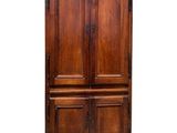 an old wooden armoire with two doors and a drawer