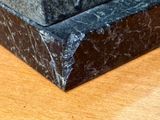 a marble box on a wooden table with a clock on it