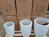 three white planters sitting on a pallet with boxes in the background