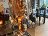 a glass table with a sculpture on it in a living room