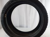 a close up of a tire on a white surface with a white curtain in the background