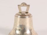 an old silver bell on a white surface with a white background