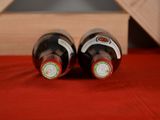 two bottles of wine sitting next to each other on a table