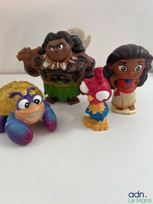 four disney figurines of different characters on a white surface