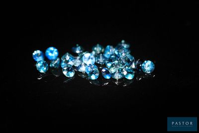 un tas de diamants bleus sur une surface noire