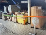 a fan sitting on the floor next to a pile of boxes