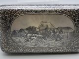 une boîte en argent sur laquelle figurent des chevaux et des personnes