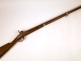 un fusil avec un canon en bois et une crosse en bois, posé sur une surface blanche