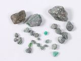 several pieces of green and white rocks and stones on a white surface