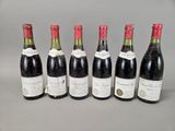 six bouteilles de vin sont alignées sur une table