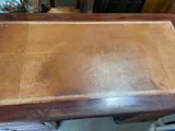 a wooden table with a brown leather top