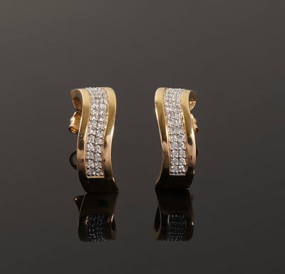 a pair of gold and diamond earrings on a black surface