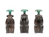 trois figurines de singes surmontées d'un palmier