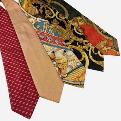 trois cravates de couleurs différentes, ornées de motifs variés sur fond blanc